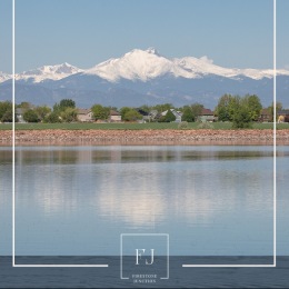 a mountain with homes and a lake in the foreground